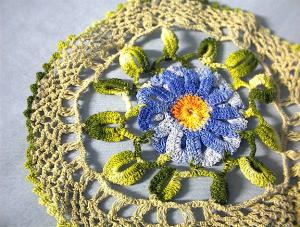 Hand Crocheted Doiley With Blue Flower.